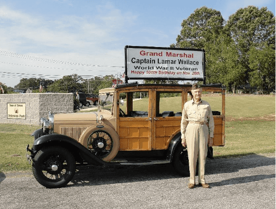 Wallace in front of army vehicle